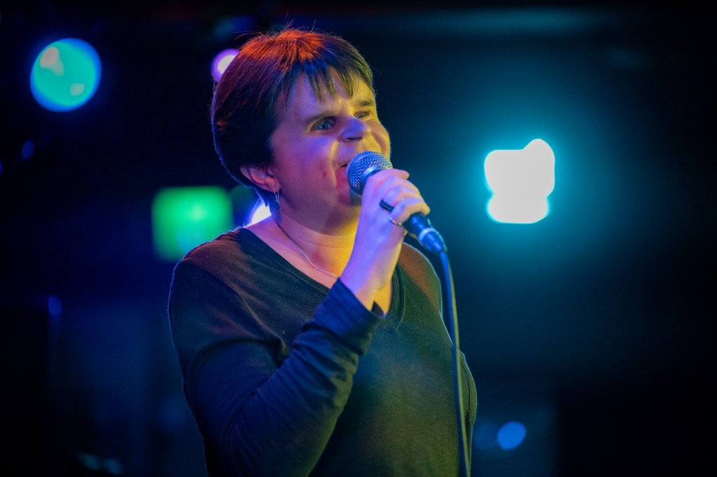 Sydney speaks to a group from stage.