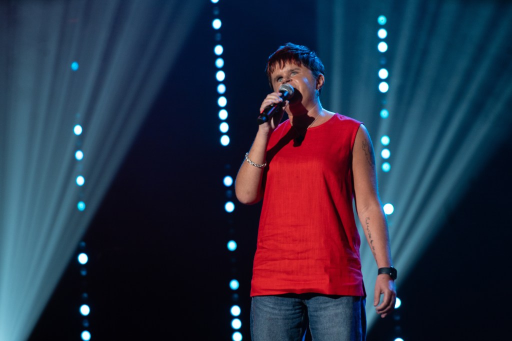 Sydney May. Award winning comedian, coach and inspirational speaker. In this picture - Sydney performs winning set at Comedy Bloomers 2025